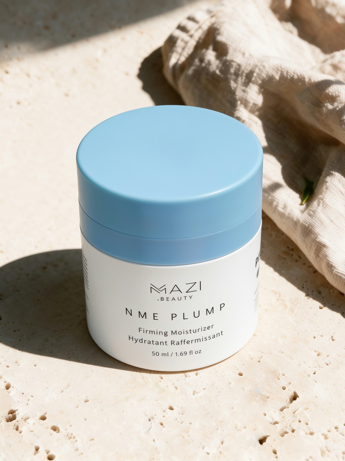 Le pot fermé de crème NME Plump de face sur du travertin, avec le texte complet de l'emballage lisible