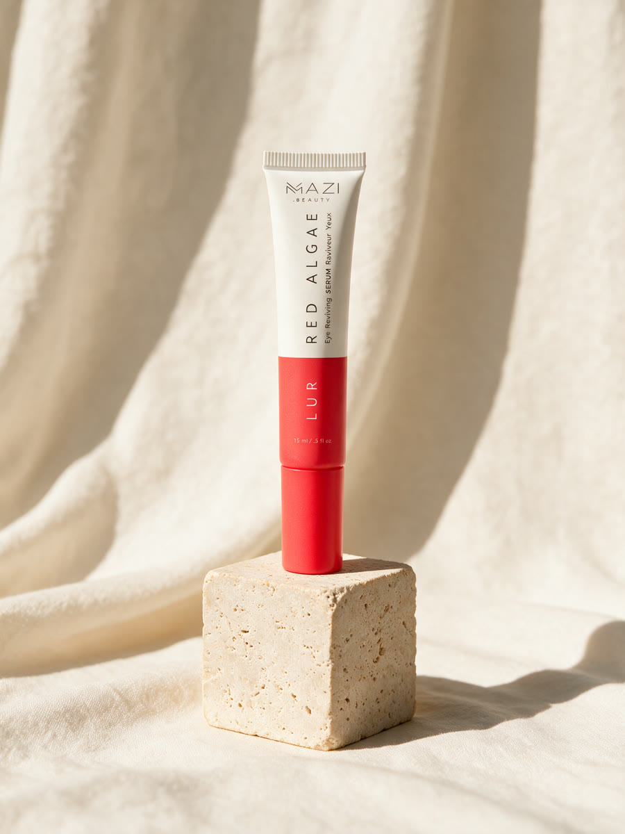 Le tube de 15 ml du sérum contour des yeux LUR sur un bloc de travertin devant du lin