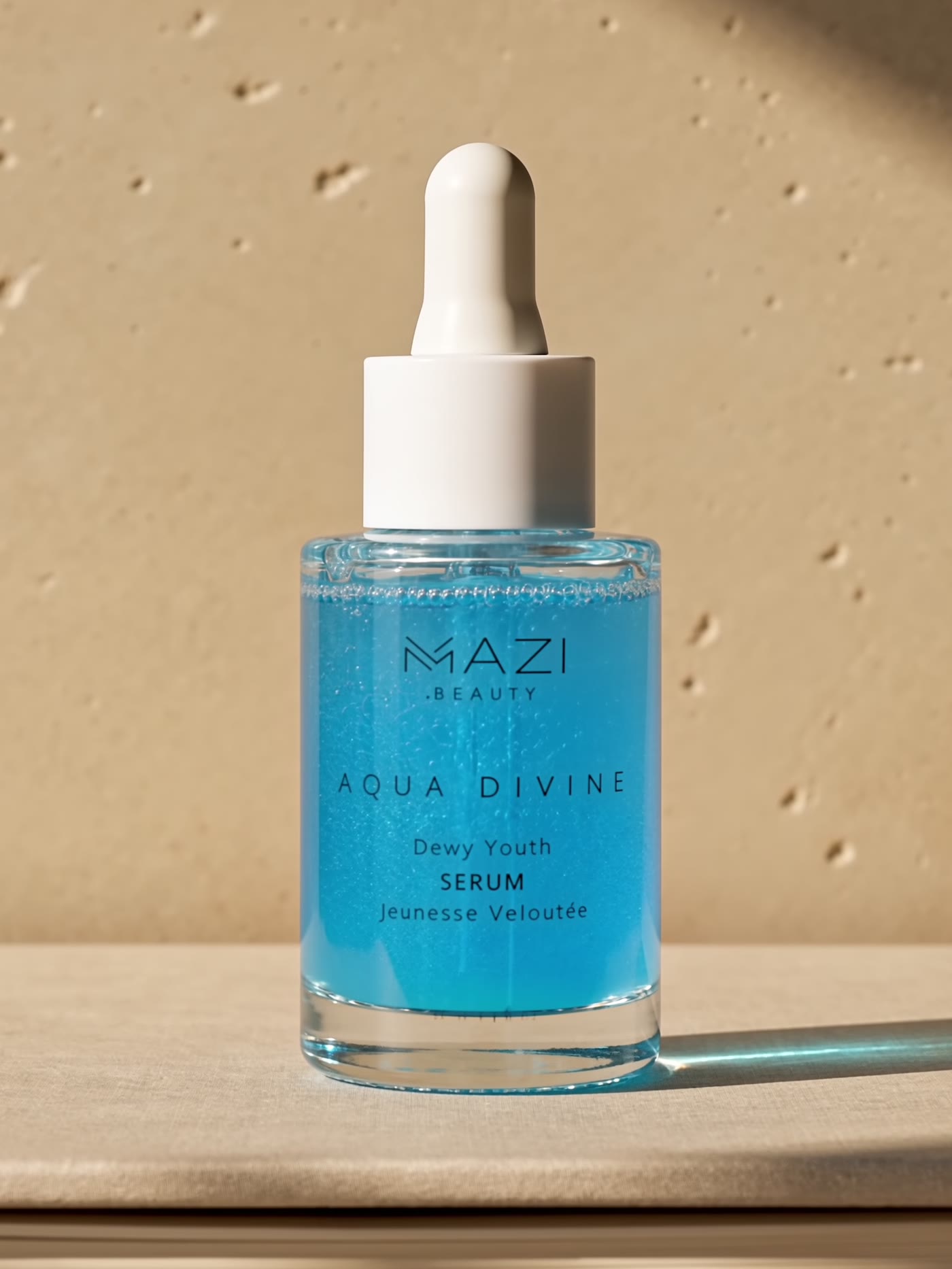 The closed Aqua Divine serum bottle standing on a stack of books against a travertine wall
