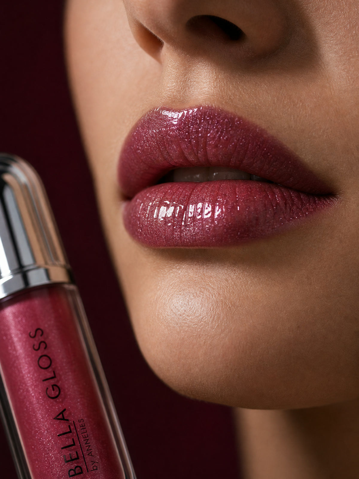 Full, glossy lips after applying Bella Gloss lip gloss, with the tube beside them