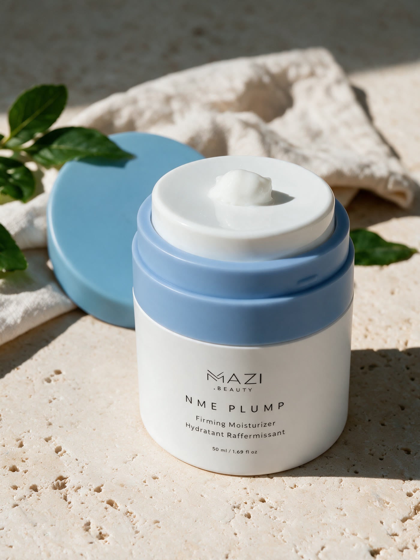 Le pot ouvert de crème NME Plump avec une noisette de crème blanche sur le bord