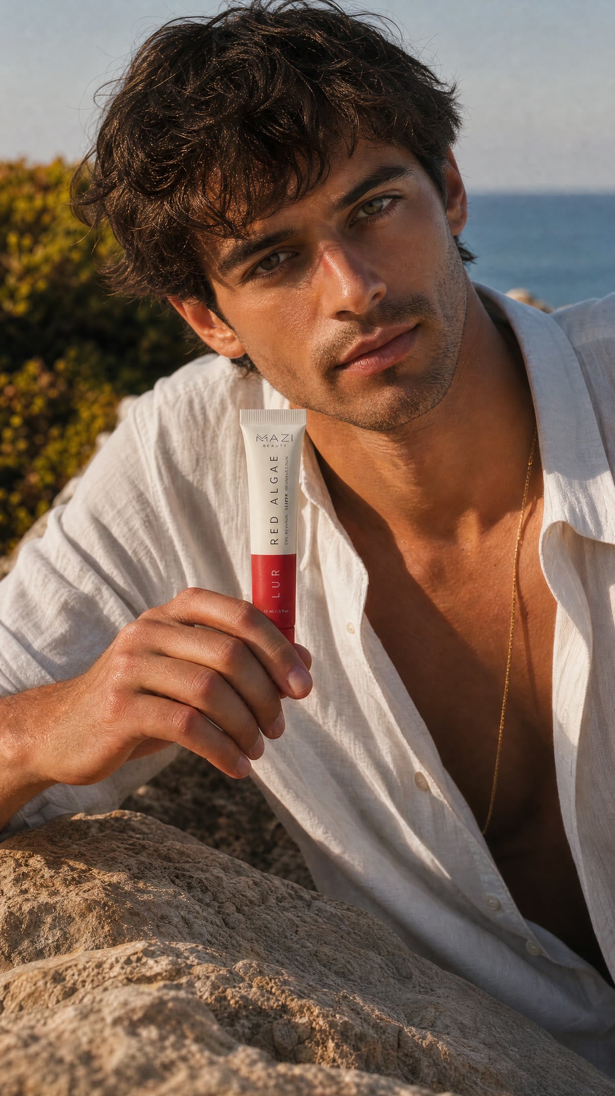 Un homme en chemise de lin blanche avec le tube, au soleil sur les rochers