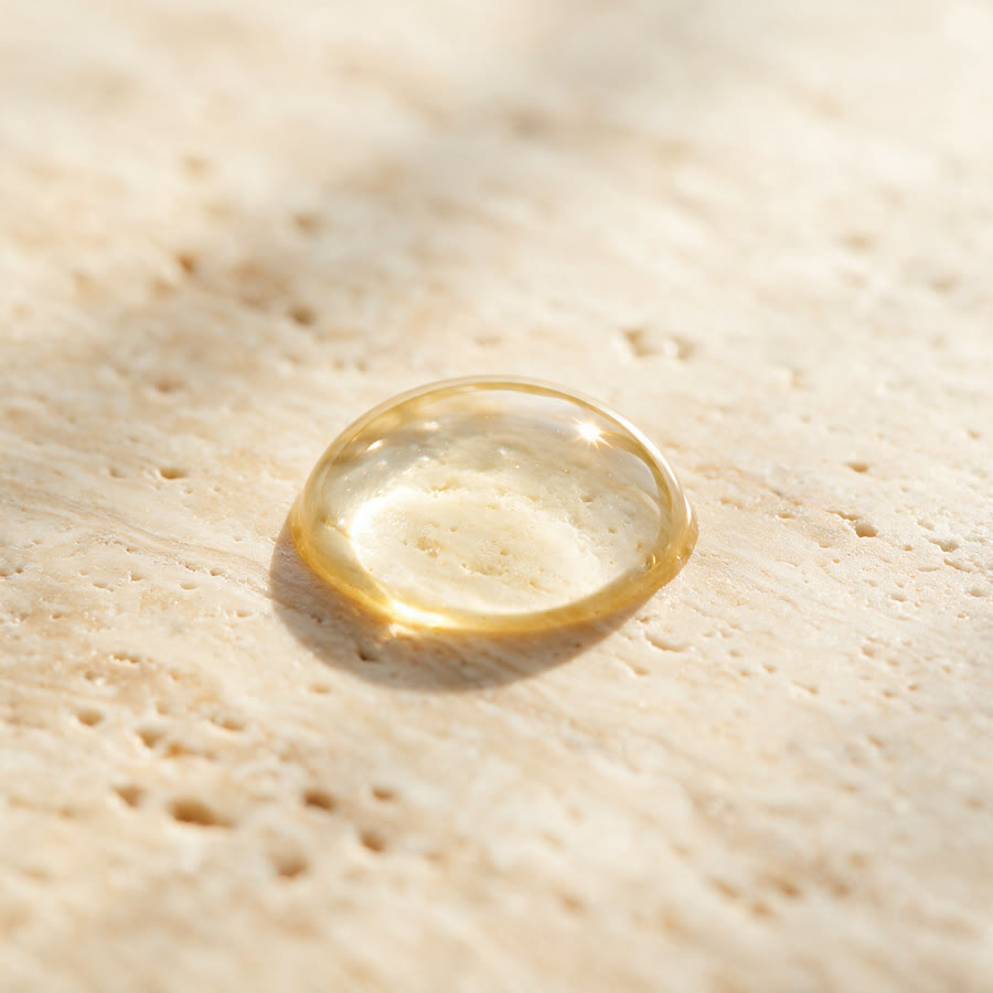 Une goutte de sérum contour des yeux LUR sur une surface en travertin