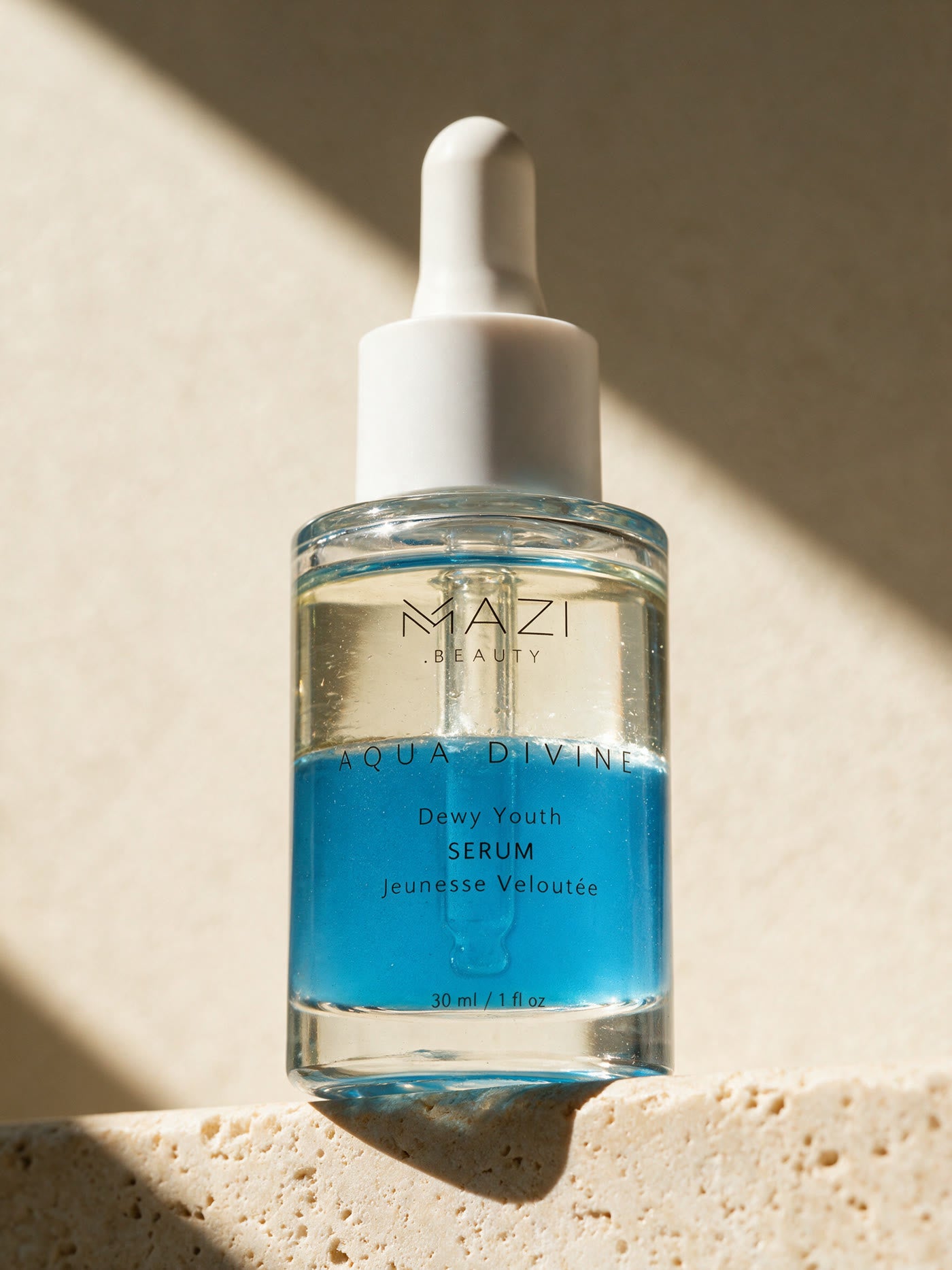 The Aqua Divine serum bottle up close, the clear oil phase resting on the blue water phase
