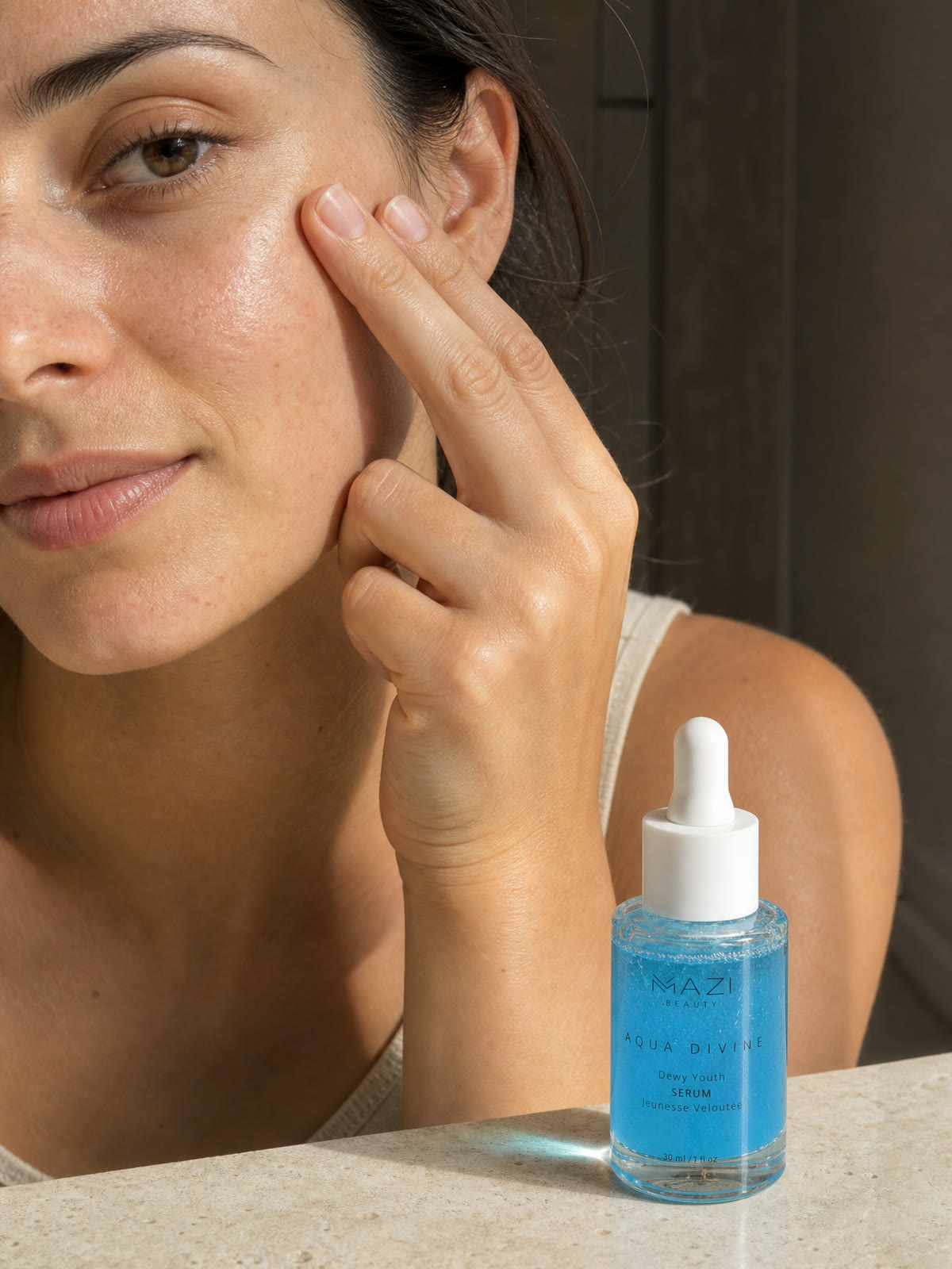 A woman presses the Aqua Divine serum into her cheek, the bottle on the counter beside her