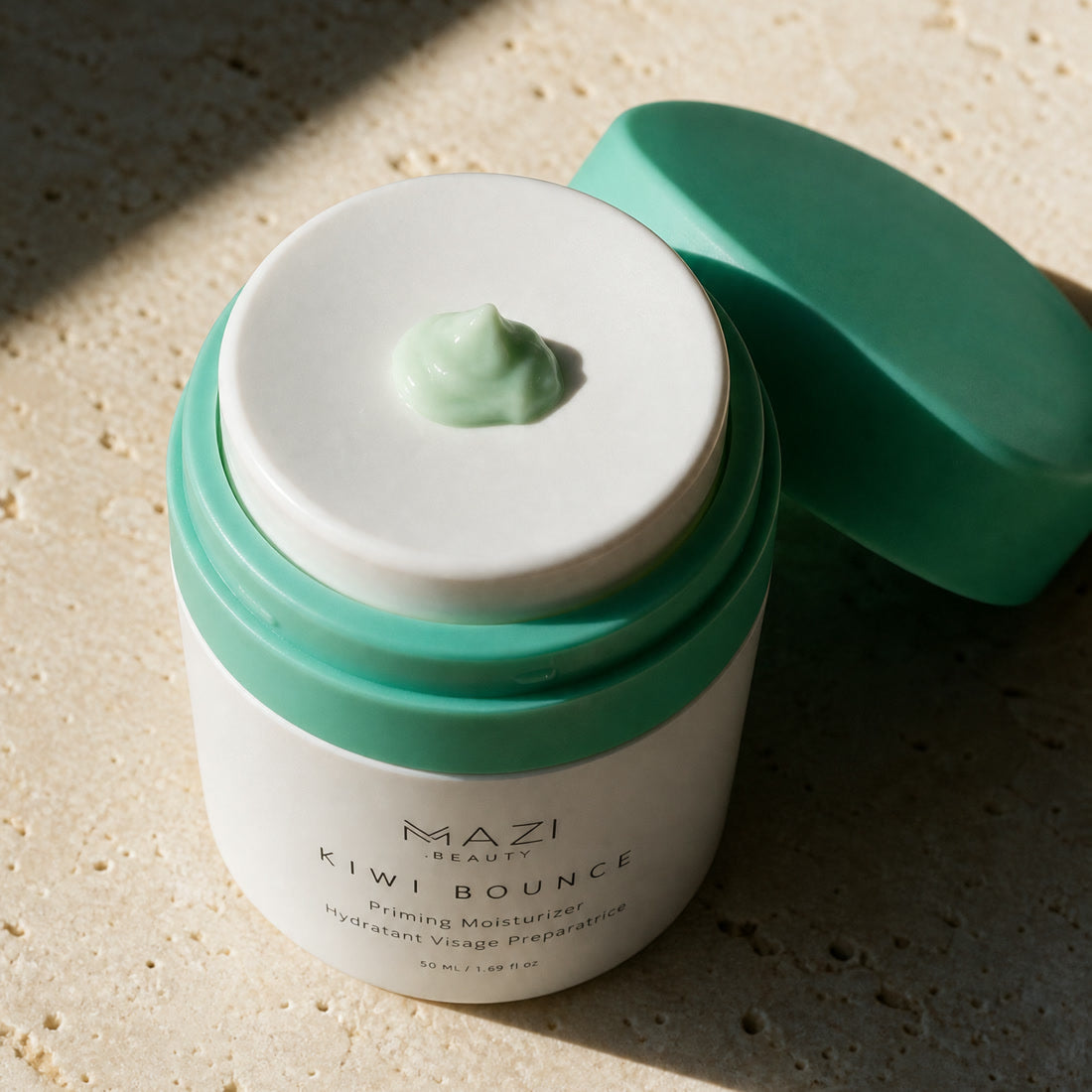 A fingertip lifts a small amount from the open Kiwi Bounce day cream jar